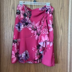 Bright floral skirt. Zipper in back, ruffle in front with tie. Very cute ☺️